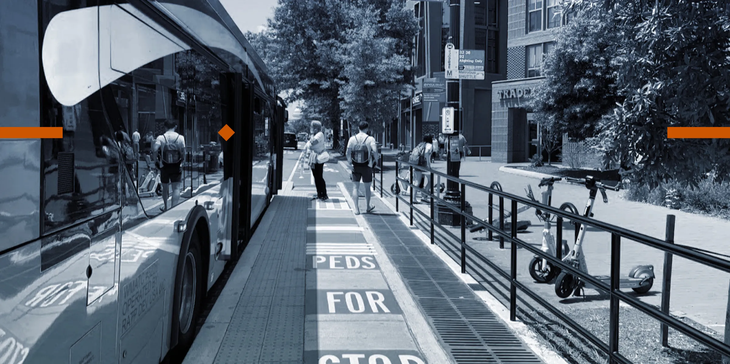 A photo of a bus stop with integrated bike lane. Passengers are boarding an arriving bus. Lettering on the bike lane surface reads "PEDS FOR STOP" in bright green stripes. Publicly-shared scooters are parked alongside the bike lane and bus stop.